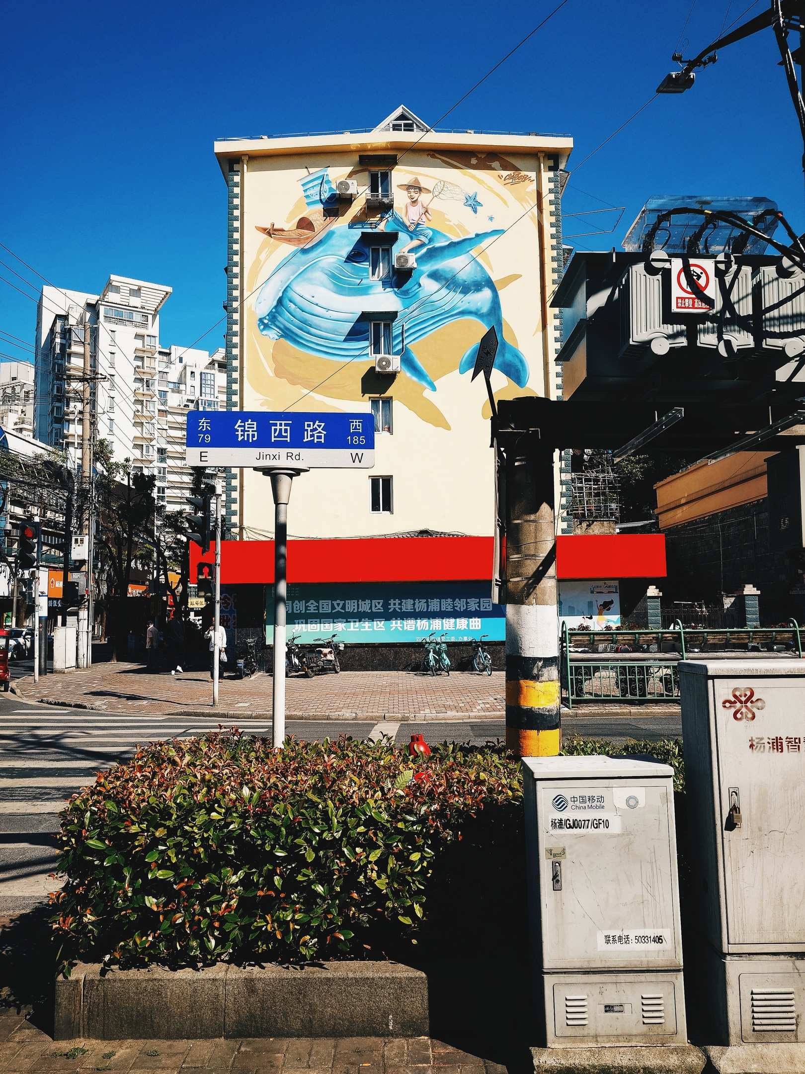 Apartment building painted with a mural of a whale carrying a fisherman.