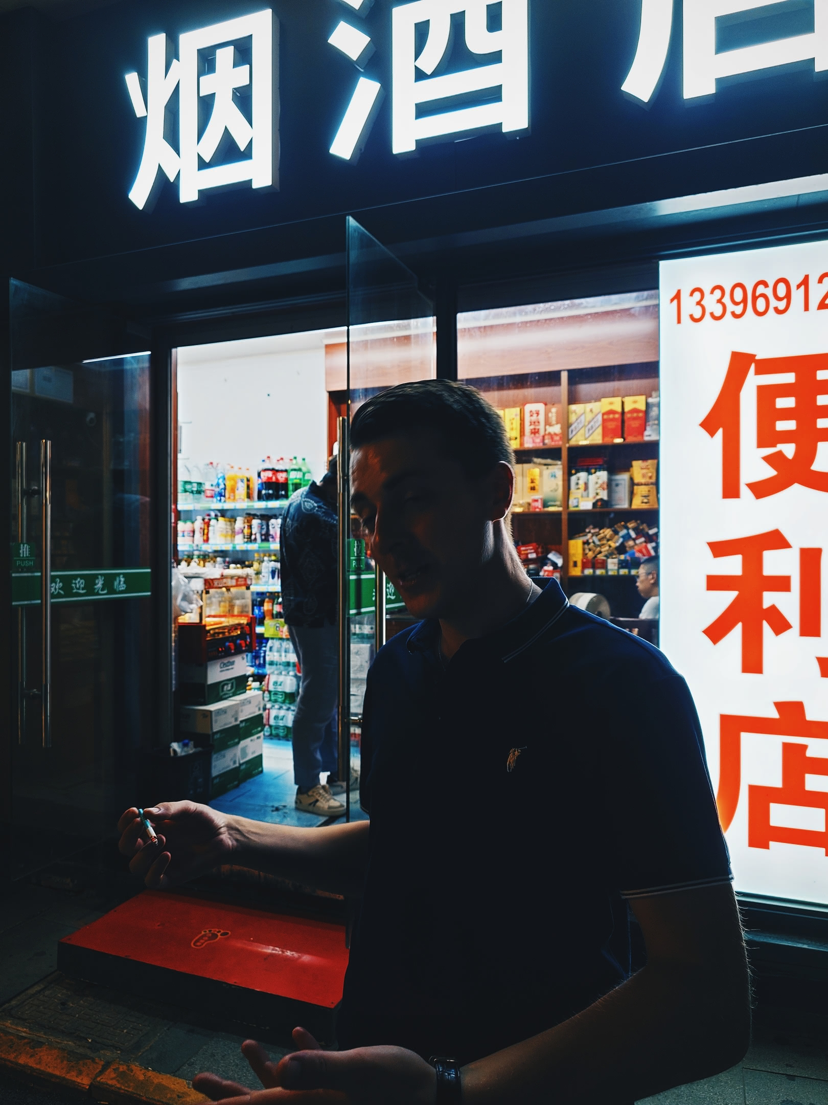 Joe posing for the camera while Jack purchases additional beers and cigarettes.