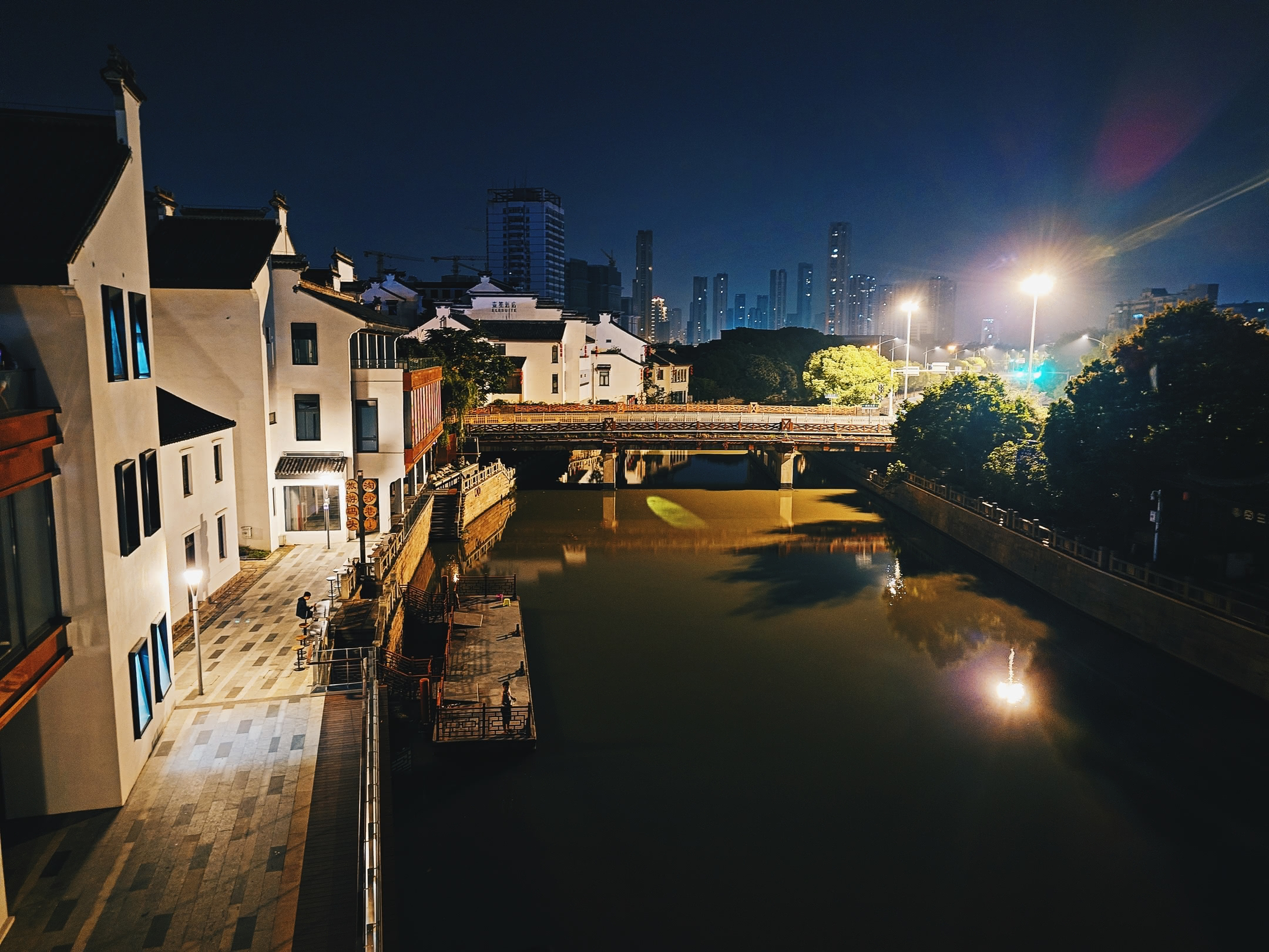 Canal at night with city buildings in background. From patio of Red Lion bar.