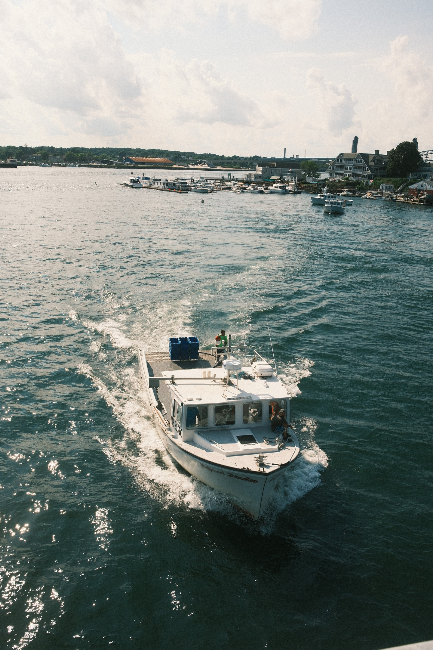 Boat passing underneath the bridge, heading out against the tide of the Piscataqua River towards the Atlantic Ocean.