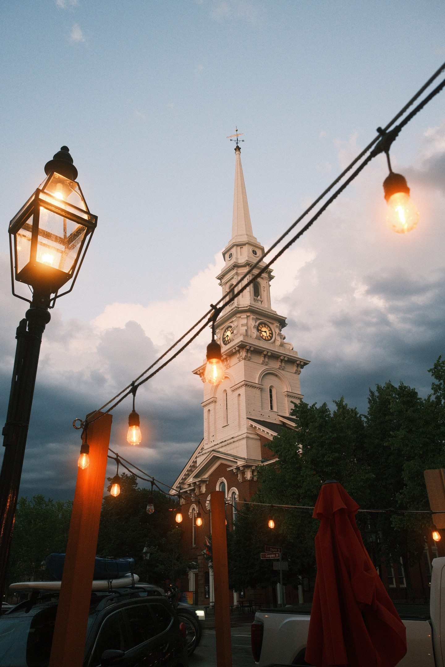 Church steeple in the evening sky after the storm, lights in the foreground.